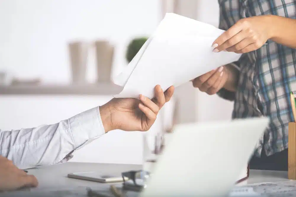 A man hands over documents, illustrating what is a process server in action