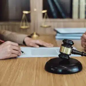 Lawyers reviewing documents with gavel present while discussing how much does a court reporter cost