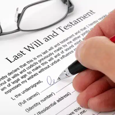 A person signs a last will and testament, highlighting the importance of legal documents
