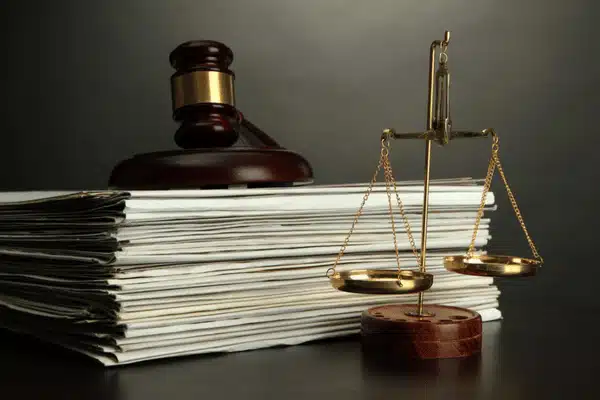 A stack of legal documents with a gavel and scales symbolizes formal legal documents