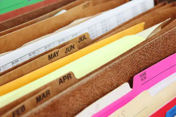 Close-up of monthly labeled file folders in a drawer, used for systematic document organization