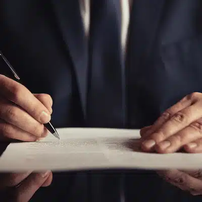 Closeup of hands signing legal documents, representing services offered by litigation support companies for cases