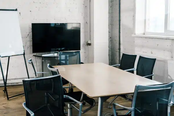 Empty conference room with table, chairs, screen, and whiteboard prepared as Office war room