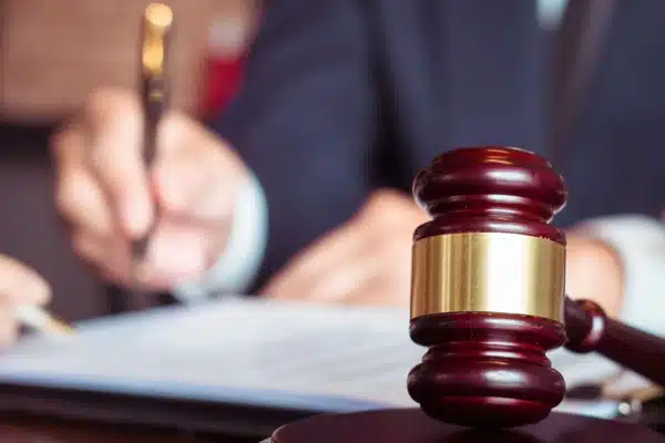 Close-up gavel beside attorney signing documents, supporting Court reporter Houston deposition and hearing records