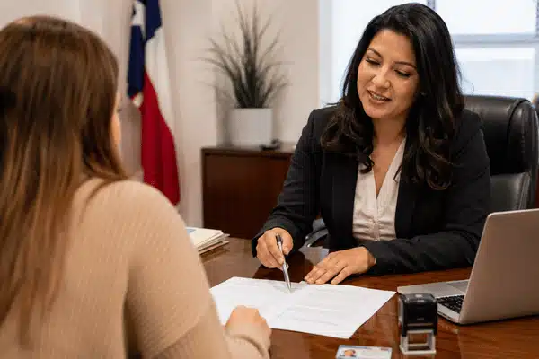 A Texas notary reviews and points to paperwork with a client during a professional legal document services appointment